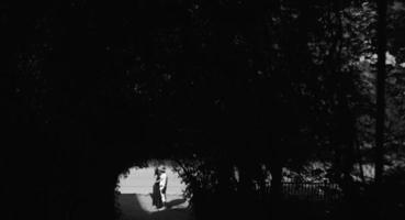 Paar springt am Ende des Tunnels mit Bäumen foto