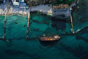 Draufsicht auf einen alten Tanker, der auf Grund lief und umkippte foto