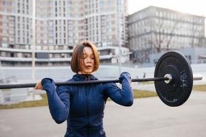 starke frau, die mit langhantel trainiert. sport, fitnesskonzept. foto