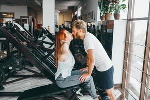 kerl küsst freundin beim training im fitnessstudio foto