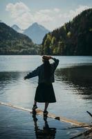 das mädchen im kleid und hut des sees in den bergen foto