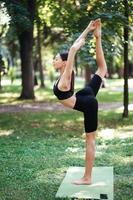 athletische junge frau, die morgens yoga im park macht. foto