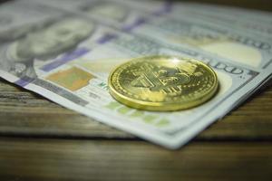 bitcoin kryptowährungsmünze und dollar auf einer holzoberfläche foto