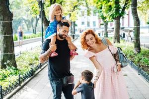 glückliche schöne familie, die im park spaziert foto