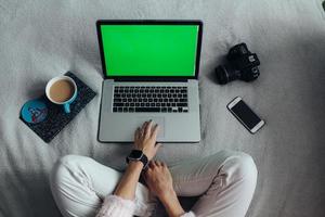 Frau mit Laptop auf ihrem Bett foto