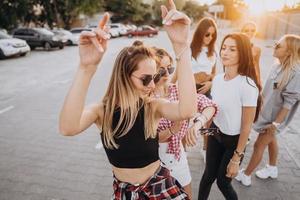 Sechs junge Frauen tanzen auf einem Parkplatz foto