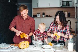 Vater, Mutter und kleiner Sohn kochen einen Kuchen foto