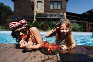 zwei kleine Mädchen auf der Seite des Pools foto