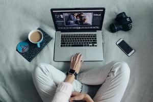 Frau mit Laptop auf ihrem Bett foto