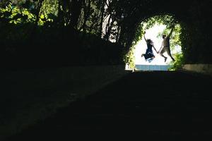 Paar springt am Ende des Tunnels mit Bäumen foto