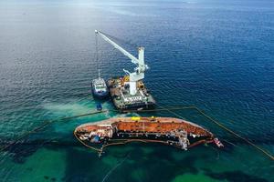 Draufsicht auf einen alten Tanker, der auf Grund lief und umkippte foto