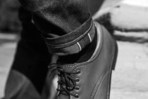 Füße von Männern in Selvedge-Jeans und Retro-Schuhen foto