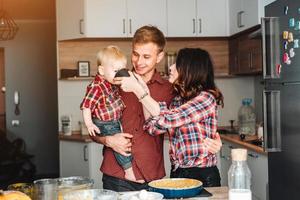 Vater, Mutter und kleiner Sohn kochen einen Kuchen foto