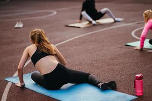 junge fitte frau in sportbekleidung trainiert draußen auf dem spielplatz. foto