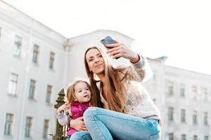 mutter und tochter sitzen zusammen auf dem zaun foto