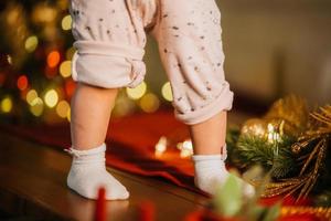 süße kleine babybeine im zimmer mit weihnachtsbaum foto