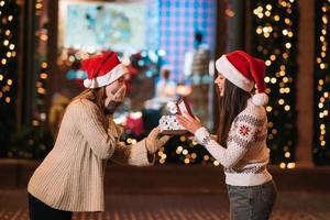 das mädchen gibt ihrer freundin auf der straße ein geschenk. foto