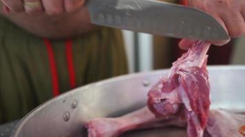 Mann trennt Fleisch von Knochen zum Kochen foto