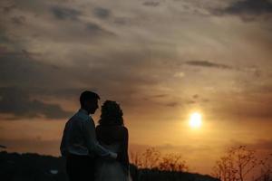 Silhouette des Hochzeitspaares im Feld foto