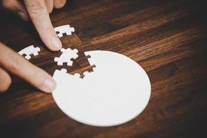 Geschäftsfrau-Personenhand mit Puzzleteilidee für Strategie und Lösung. Closeup Teil von zwei weißen Puzzles verbinden sich. konzept des gemeinsamen zusammenarbeitserfolgs teamwork-problem unternehmensteam. foto