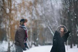 Mann und Frau werfen Schneebälle foto