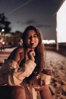 junge frau sitzt auf stuhl am nachtstrand foto