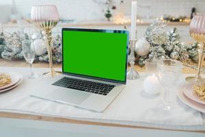 laptop mit grünem bildschirm - chromakey in der nähe von neujahrsdekorationen. Weihnachtsthema. foto