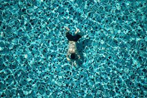 Mann schwimmt im Pool des Hotels. Sicht von oben. foto