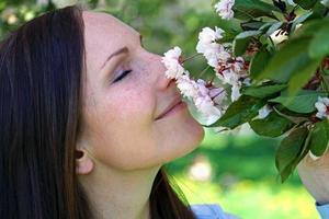 attraktive frau, die blumen riecht foto