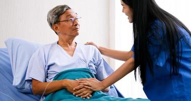 medizinische assistentin, die sich um erwachsene patienten im krankenzimmer kümmert. foto