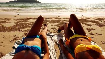 Zwei sexy Frauen liegen zusammen am Strand. foto