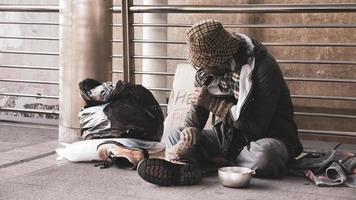 Obdachloser sitzt auf dem Boden im Freien. foto