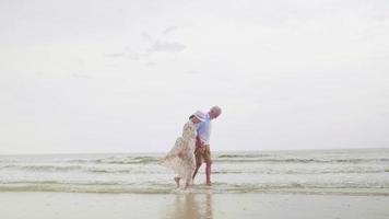 glückliche paare, die zusammen am strand spazieren gehen. foto