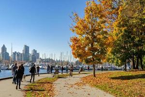vancouver, kanada - oktober 20,2018 nicht identifizierte touristen im stanley park mit herbstfarbe der ahornbäume entlang des seawall weges in vancouver, britisch kolumbien, kanada. foto