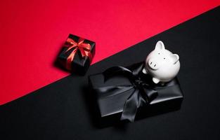 Draufsicht auf schwarze Geschenkbox mit roten und schwarzen Bändern isoliert auf schwarzem Hintergrund. foto