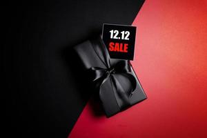 Draufsicht auf schwarze Geschenkbox mit schwarzem Hintergrund mit Kopierplatz für Text 12.12 Singles Day Sale. foto