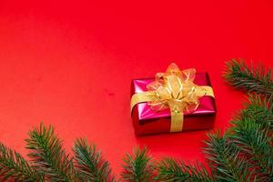 Weihnachtshintergrundkonzept. Draufsicht der Weihnachtsgeschenkbox Goldkugeln mit Fichtenzweigen foto
