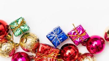 frohe weihnachtskarte aus tannenzweigen, geschenkboxen, roter dekoration, funkeln und konfetti auf weißem hintergrund. foto