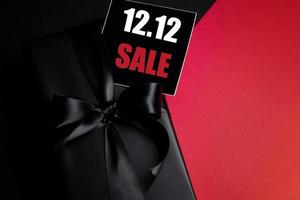 Draufsicht auf schwarze Geschenkbox mit schwarzem Hintergrund mit Kopierplatz für Text 12.12 Singles Day Sale. foto