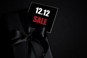 Draufsicht auf schwarze Geschenkbox mit schwarzem Hintergrund mit Kopierplatz für Text 12.12 Singles Day Sale. foto