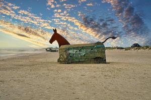 am strand in blavand, dänemark mit blick auf einen bunker mit pferdekopf foto