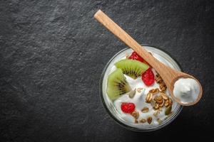 hausgemachter Joghurt mit Müsli, Kiwi, Trockenfrüchten und Bio-Nüssen - gesündeste Saat. foto