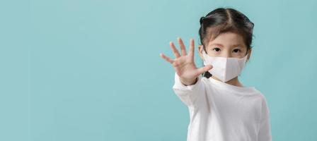 asiatisches kleines mädchen trägt medizinische gesichtsmasken, um sich vor verschmutzung zu schützen foto