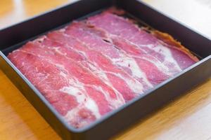 Austernklinge ist frisches Rindfleisch, roh in Scheiben geschnitten, wurde für Sukiyaki, koreanisches gegrilltes Rindfleisch und Shabu- oder Yakiniku-Restaurant serviert, das es auf einen schwarzen Teller legte. foto