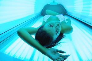 schöne junge Frau im Solarium bräunen foto