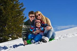 familie, die spaß auf frischem schnee im winter hat foto