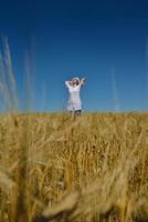 junge Frau im Weizenfeld im Sommer foto