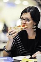 Frau isst Pizza im Restaurant foto