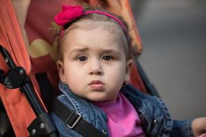 Babymädchen, das im Kinderwagen sitzt foto