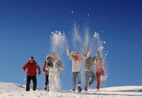 freunde haben spaß im winter auf frischem schnee foto